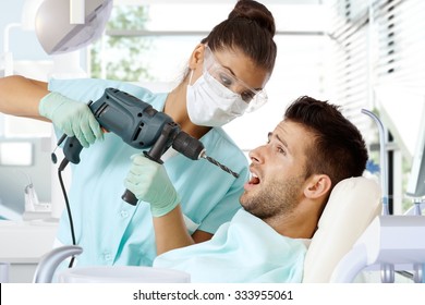 Aggressive Female Dentist Drilling Tooth With Power Drill.