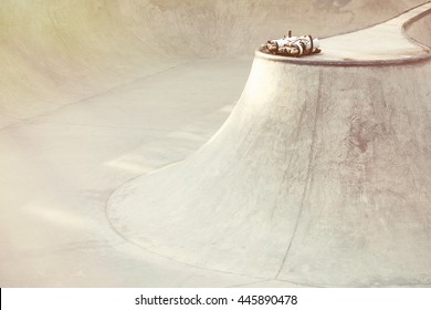 Aggressive inline skates lying on concrete ramp in outdoor skate park. Rollerblades for tricks and grinds, no models