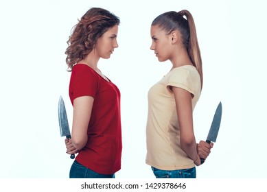Aggressive Jealous Women Fighting. Girls Hide Knives behind Back. Enemies Going to Kill Concept Photo on White Background.