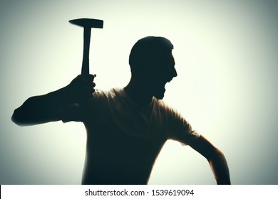 aggressive man attacks with a hammer. 