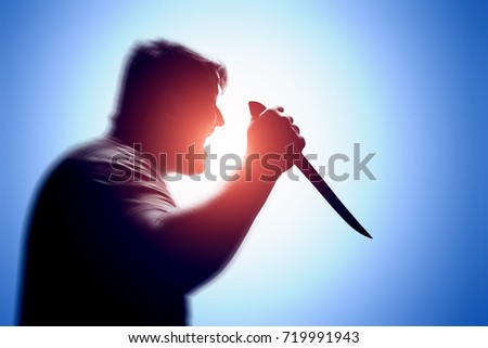 An aggressive man attacks with a knife. Stabbing attack. Hand with a knife. Murder with a knife.