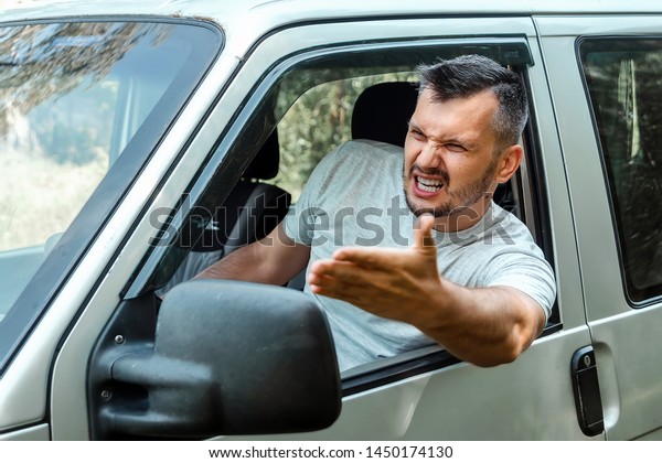 Aggressive Man, the driver of the car is outraged\
at the wheel during the trip. Emergency, accident, violation of\
rights, dispute, bad\
driver.