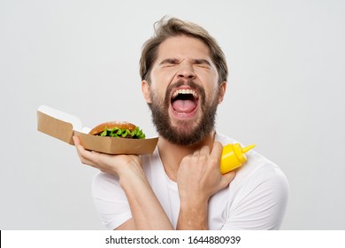 aggressive man emotions. Mustard and hamburger in paper packaging