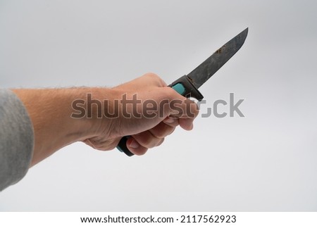 Aggressive man holding a knife. Using deadly weapon for attacking or defending. Aggressor with a sharp lethal weapon. Holding a knife like its ready to stab. White background high resolution image.