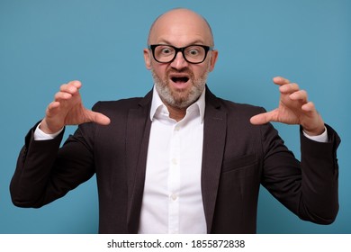 Aggressive Mature Italian Man In Glasses Posing Isolated On Blue Wall.