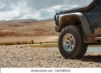 Aggressive off road ready car in mountains. Closeup photo of mud terrain wheel - Powered by Shutterstock