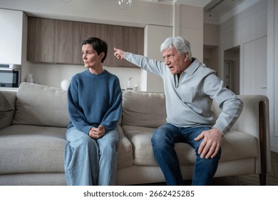 Aggressive old man gesturing showing to exit, gaslighting wife in abusive communication at home. Marital conflict, toxic relationship, dependency struggle, woman suffering, elderly family crisis