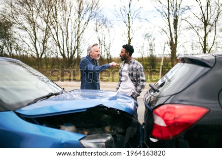 Aggressive senior male driver arguing over blame for car accident with a younger male motorist