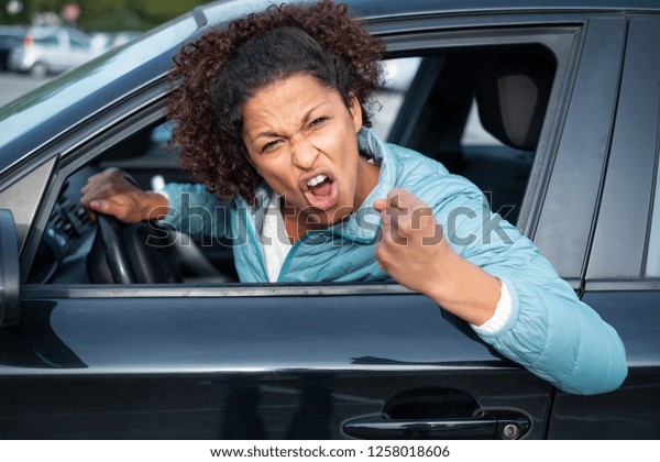 Aggressive woman\
driving car shouting at\
someone
