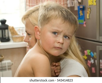 Aggrieved 4 Y.o. Boy With Wide Opened Gray Eyes On His Mom Arms In The Kitchen