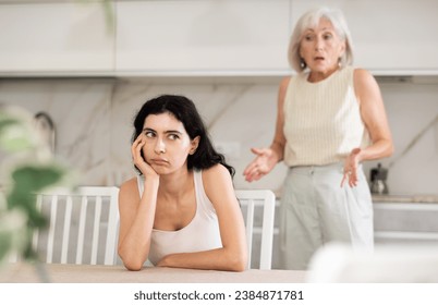 Aggrieved elderly woman having quarrel with her daughter at home. Elderly mother expresses claims to adult daughter - Powered by Shutterstock