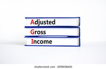 AGI adjusted gross income symbol. Concept words AGI adjusted gross income on books. Beautiful white table, white background, copy space. Business and AGI adjusted gross income concept.