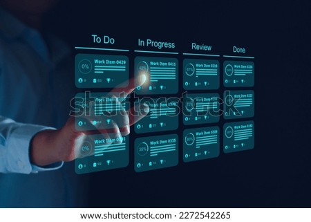 Agile software development or project management using kanban or scrum methodology boards on screen. Process, workflow, visual organisation tools and framework. Developer touching virtual interface.