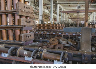 Aging equipment on floor of abandoned turn of the century silk throwing factory.