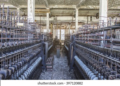 Aging factory floor with antique equipment rusting in turn of the century silk throwing factory.