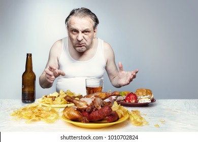 Aging man in a-shirt eating lot of junk food.