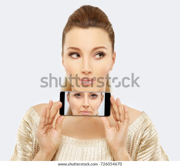Aging. Mature woman-young woman.Face with skin\
problem.Before and after cosmetic procedures,showing photos on your\
smartphone
