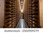 Aging rooms with many shelves in cheese caves, central location for aging of wheels, rounds of Comte cheese from four months to several years made from raw cow milk, Jura, France