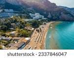 Agios Gordios exotic beach in Corfu island,Greece. Agios Gordios beach, Corfu island, Greece. Panoramic view of the Agios Gordios beach, sandy seashore with beach umbrellas and deck chairs.