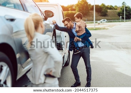 An agitated family with a small child wait for a tow truck to take away their broken car.