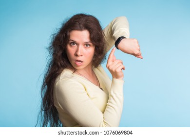 Agitated Young Woman Pointing Her Wrist Watch Over Blue Background