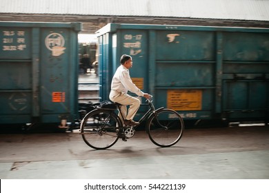 AGRA, INDIA - 14 FEBRUARY 2013: Man cycling on a platform at the Agra train station in Agra, India. Cycling accounts for 50 to 75% of commuter trips in the informal sector in urban areas.
