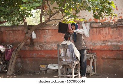 Agra, India - 2/21/2011:  A Barber Has Set Up Shop On A Sidewalk In Downtown Agra