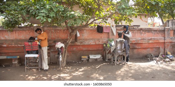 Agra, India - 2/21/2011:  Two Barbers Set Up Shop On A Sidewalk In Downtown Agra