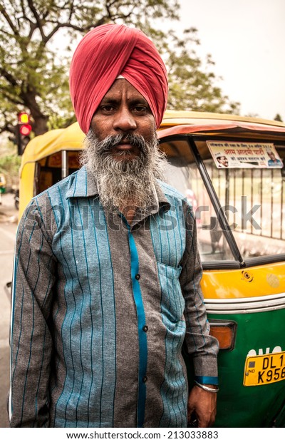 AGRA, INDIA - APRIL 12: Unidentified man who dress\
Indian tradition costume hat and drive public car transportation\
that\'s call \'Auto Rickshaw\' It\'s popular and cheap travel in India\
on Apr 12, 2014