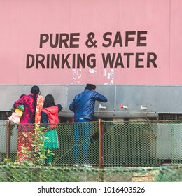 Agra / India - DEC 24th 2017: A Family Drinking From A Public Tap That Says: Pure & Safe Drinking Water