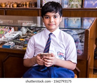 Agra, India: July 18, 2017, School Boy With Cell Phone In Parents' Shop, Agra