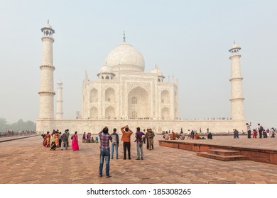 AGRA, INDIA - NOVEMBER 17, 2012: Tourists Visit Taj Mahal - Famous Indian Landmark And Tourist Attraction. It Is UNESCO World Heritage Site And Considered As One Of Most Beautiful Buildings In World