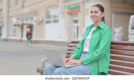 Agree Hispanic Woman Shaking Head In Approval While Sitting On Bench Outdoor