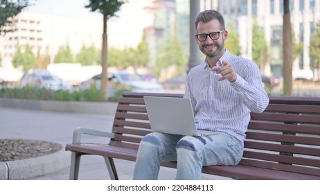 Agree Young Adult Man Shaking Head In Approval While Sitting On Bench Outdoor