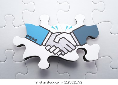Agreement, consensus building and strategic partnership concept.Sharing mutual interest. Achieving settlement. Assembling handshake jigsaw puzzle.