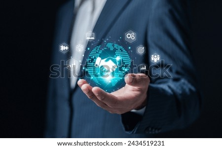 Agreement, partnership or deal concept. Business joint venture, data exchange customer connection, teamwork and successful business. Businessman hold globe with handshake icon on virtual screen.