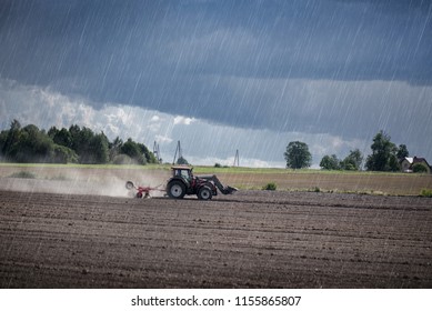 Agricultural Background. Tractor Pulling Plow, Throwing Dust In Air. Combine Harvester At Wheat Field. Heavy Machinery During Cultivation, Working On Fields. Dramatic Sky, Sun Rays, Rain, Storm Clouds