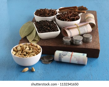 Agricultural income, from spices like cinnamon, pepper, cardamom, cloves, star anise and bay leaves, concept highlighted with Indian rupees, which are rolled, and stacks of coins. - Powered by Shutterstock