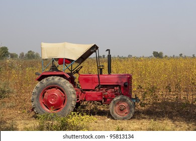 Agricultural Landscape With A Red Tractor In A Cotton Field In Gujarat India In The Dry Season