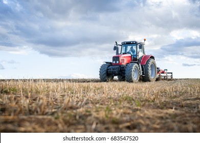 agricultural machinery in the foreground carrying out work in the field