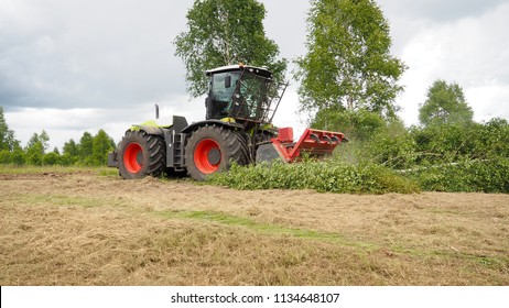 Agricultural Machinery In Operation, The Tractor With The Mill Cuts Down Trees, Clearing Of Land.