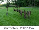 Agricultural machinery, wheel-finger rake. Old hay rake equipment. Rural field, countryside,rake hay turner. field work. farm