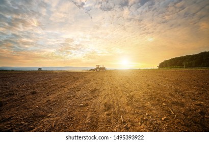 Agricultural People Use A Tractor As A Tillage Machine, Which Has A Wide Area To Prepare The Soil For Growing Corn On The Farm.Beautiful Sky Clouds And Sunlight Background Copy Space.