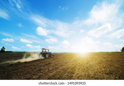 Agricultural People Use A Tractor As A Tillage Machine, Which Has A Wide Area To Prepare The Soil For Growing Corn On The Farm.Beautiful Sky Clouds And Sunlight Background Copy Space.