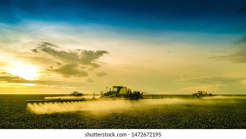 Agricultural sprayers making application at the end of the day with beautiful sunset - Shutterstock ID 1472672195