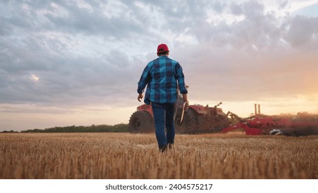 agriculture. farmer walk works in a field next to a tractor that plows the land. business agriculture concept. farmer with tablet works in field next to a tractor at farm sunset mowed wheat plows - Powered by Shutterstock