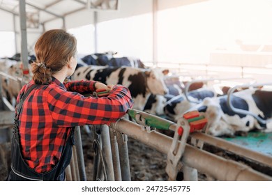 Agriculture Farming livestock cattle industry. Happy smiling young woman farmer plaid shirt and uniform on background cows dairy farm. - Powered by Shutterstock