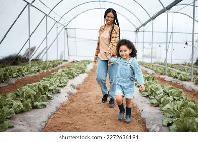 Agriculture, greenhouse and mother walking with girl for gardening, farming and harvest vegetables together. Black family, nature and happy child with mom on farm for growing plants, food and produce - Powered by Shutterstock