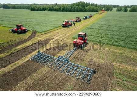 Agriculture machine harvesting crop in fields. Tractor pulls a mechanism for haymaking. Harvesting in autumn in the morning at dawn. agribusiness in the Altai region Russia. aerial view from above