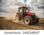 Agriculture machinery in action, a tractor plows a field on a bright day